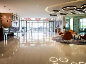 a lobby with chairs and a table in a building at Novotel Yanbu Albahr in Yanbu