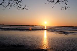 - un coucher de soleil sur la plage dans l'établissement Ferienhaus Wattwurm 1, FeWo Vermittlung Nordsee, à Dangast