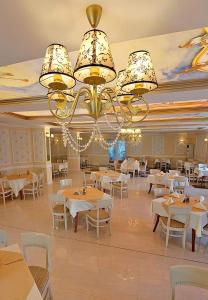 Hotel Rila في دوبنيتسا: غرفة طعام بها طاولات وكراسي وثريا