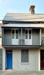 a house with a blue door and a balcony at Coco’s Abode in Sydney