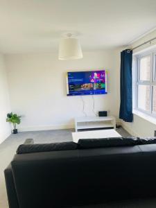 a living room with a couch and a flat screen tv at Anox serviced apartment in Newcastle upon Tyne
