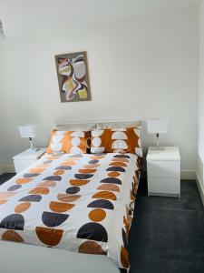 a bed in a bedroom with two night stands and two tables at Anox serviced apartment in Newcastle upon Tyne