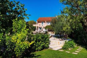 ein Haus mit einem Garten mit Bäumen und Sträuchern in der Unterkunft Villa Beauty Luxury Vodice in Vodice