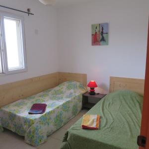 a bedroom with two beds and a window at Casa Krioula in Calheta Do Maio