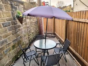 una mesa y sillas con una sombrilla en el patio en *16*b* setup for your most amazing & relaxed stay + Free Parking + Free Fast WiFi * en Morley