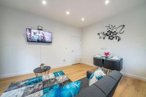 a living room with a couch and a tv at *16*b* setup for your most amazing & relaxed stay + Free Parking + Free Fast WiFi * in Morley