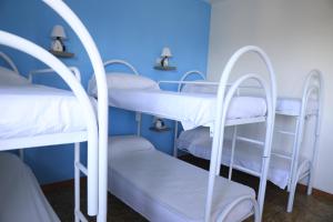 een groep stapelbedden in een kamer met blauwe muren bij First Hostel Tropea in Tropea