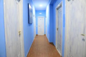 einen Flur mit blauen Wänden und einem langen Flur in der Unterkunft First Hostel Tropea in Tropea