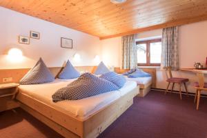 1 dormitorio con 2 camas y almohadas azules en Ferienhof Haderlehn, en Sautens