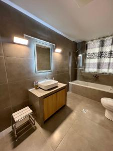 a bathroom with a sink and a toilet and a tub at Villa 56 Luxury apartments in Rhodes Town