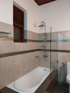 La salle de bains est pourvue d'une baignoire et d'une douche. dans l'établissement Comfy Home near the town, à Maharagama