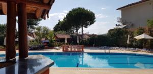 a swimming pool with chairs and umbrellas at Boncuklu Otel in Fethiye +16 photos