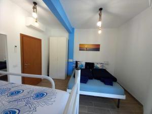 VELA vicino al mare BluDiPietraLigure في بيترا ليغوري: غرفة نوم مع سرير بسقف ازرق