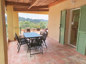 eine Terrasse mit einem Tisch und Stühlen auf einer Terrasse in der Unterkunft Villa L'Olivade in Châteauneuf