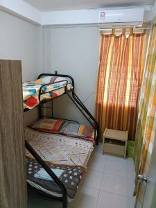 a small room with two bunk beds and a window at J & I Homestay B 3 Person with shared bathroom in Sibu