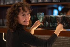 a woman holding up two wine glasses at Hotel Krokus in Pec pod Sněžkou