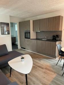 a living room with a white table and a kitchen at Esbjerg Camping in Esbjerg