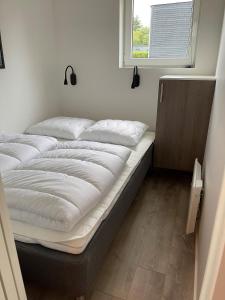 Cette chambre comprend un grand lit et une fenêtre. dans l'établissement Esbjerg Camping, à Esbjerg