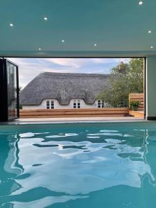 ein Swimmingpool mit einem Haus, durch ein Fenster gesehen in der Unterkunft A luxury unique home spa - White Stones Retreats. in Weymouth