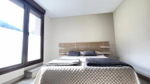 a bedroom with a large bed with blue pillows at Lapaserina-A in Arenas de Cabrales