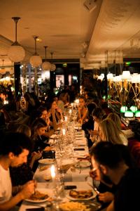 a group of people sitting at a long table in a restaurant at Hôtel Thoumieux in Paris