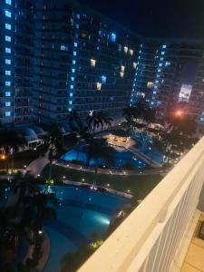 a view of a swimming pool at night at SHELL RESIDENCE C9 NEAR AIRPORT & MALL OF ASIA in Manila