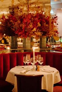 a table with wine glasses and a candle on it at Hôtel Thoumieux in Paris