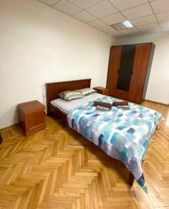 um quarto com uma cama e piso em madeira em Apartments on Moskovskaja em Dnipro