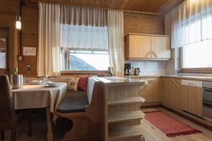 eine Küche mit einem Tisch und einem Sofa in einem Zimmer in der Unterkunft Ferienhof Haderlehn in Sautens