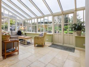 an empty conservatory with a glass ceiling at Barebones Farm in Winchcombe
