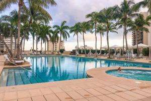 una piscina con palmeras y una persona en ella en Exclusive Condo at Four Seasons Brickell with Great Views, en Miami