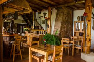 un restaurante con mesas y sillas de madera y una escalera en Hartbeespoortdam Lodge, en Hartbeespoort