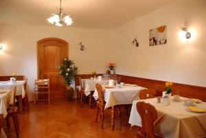 restauracja ze stołami i krzesłami z białym blatem w obiekcie Pension Tannhof w mieście Fuschl am See