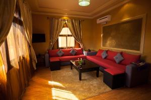 Charming apartment - secure and close to Marrakech no69 في تهنوت: غرفة معيشة مع أريكة حمراء وطاولة