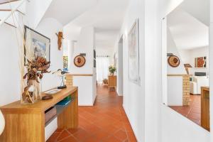 a hallway with white walls and orange tile floors at Villa Farol by OCvillas in Galé