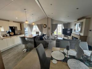 a kitchen and a living room with a table and chairs at Kestral Court Lodge, Scratby - California Cliffs, Parkdean, sleeps 6, bed linen and towels included, wrap around decking - no pets in Scratby