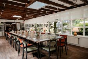 a long dining room with a long table and chairs at De Lunterse Boer in Lunteren