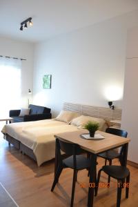 Apartamenty na Ceglanej في أوشفيتز: غرفة نوم بسرير وطاولة مع طاولة