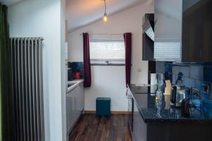 a kitchen with a black counter top and a radiator at The Rum Shack Manorbier Castle Inn in Manorbier