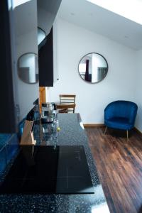 uma cozinha com uma bancada preta e um espelho em The Rum Shack Manorbier Castle Inn em Manorbier