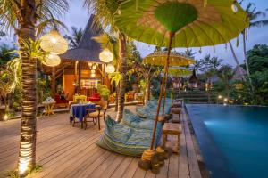 a resort with a pool and umbrellas on a deck at Menzel Ubud in Ubud