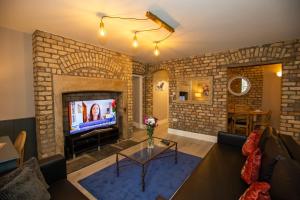 a living room with a brick wall with a tv at Ballsbridge Apartments in Dublin