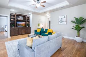 a living room with a couch and a ceiling fan at Manassas House 4 BDR Patio Firepit in Tallahassee