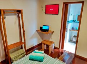 um quarto com uma cama e um computador portátil numa secretária em Casa da Lua Estrela em Visconde de Mauá
