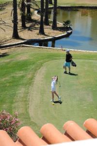 dos personas jugando golf en un campo de golf en Renovated Vale do Milho Golf Apartment with sea view, en Carvoeiro