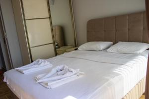 a bed with two white towels sitting on it at Vacation home with private pool, Fethiye, Oludeniz in Cedit