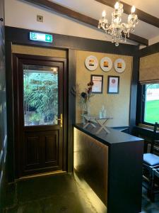 a bar in a restaurant with a door and a chandelier at The Old Mill Inn in Forres