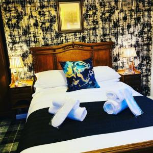 een slaapkamer met een bed met twee handdoeken erop bij The Old Mill Inn in Forres