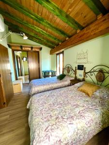 1 dormitorio con 2 camas y techo de madera en Casa Rural Juan de Austria en Cuacos de Yuste