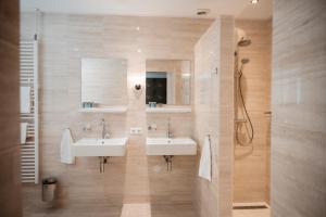 a bathroom with two sinks and a shower at De Lunterse Boer in Lunteren